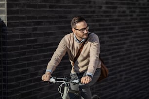 An urban man riding a bike on the street.