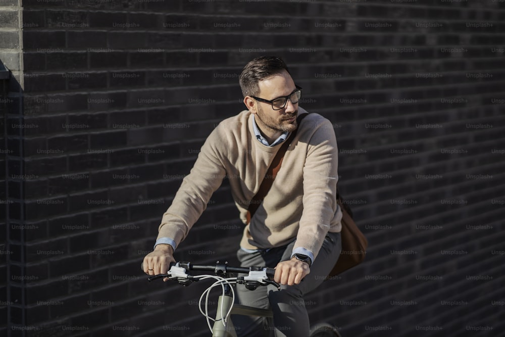 An urban man riding a bike on the street.