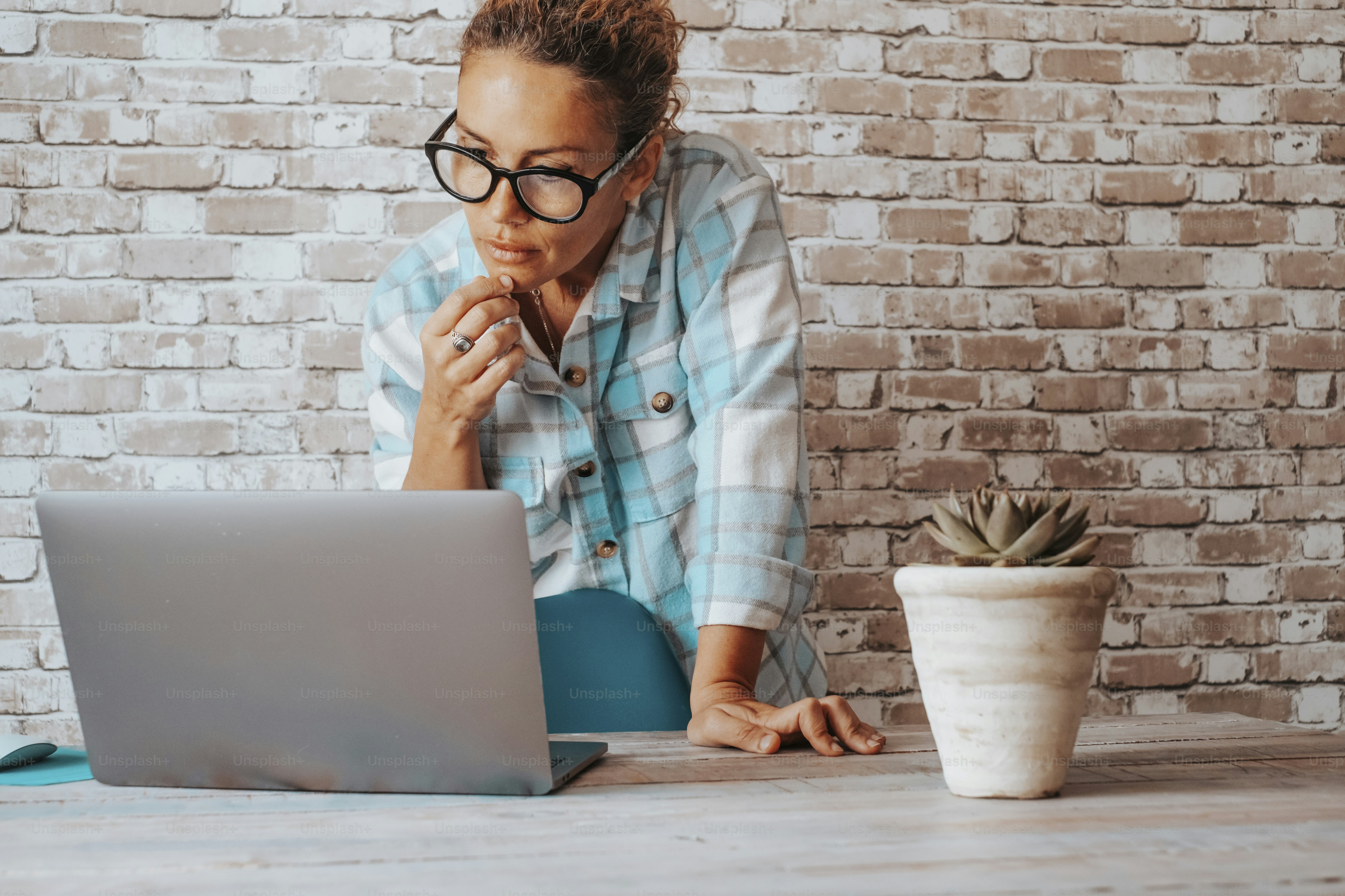 Online business people lifestyle and modern job concept. Woman standing in front of computer looking with doubts and thoughtful expression. Stock crypto market worker studying and reading notifications