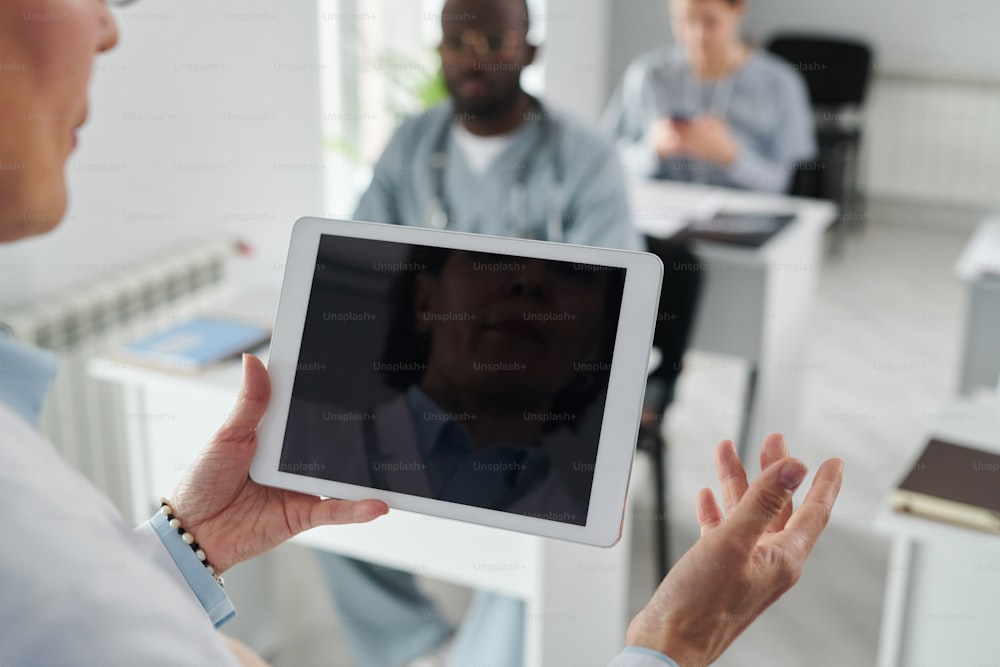 Nahaufnahme einer Ärztin mit digitalem Tablet während ihres Vortrags auf einer Konferenz für Studenten