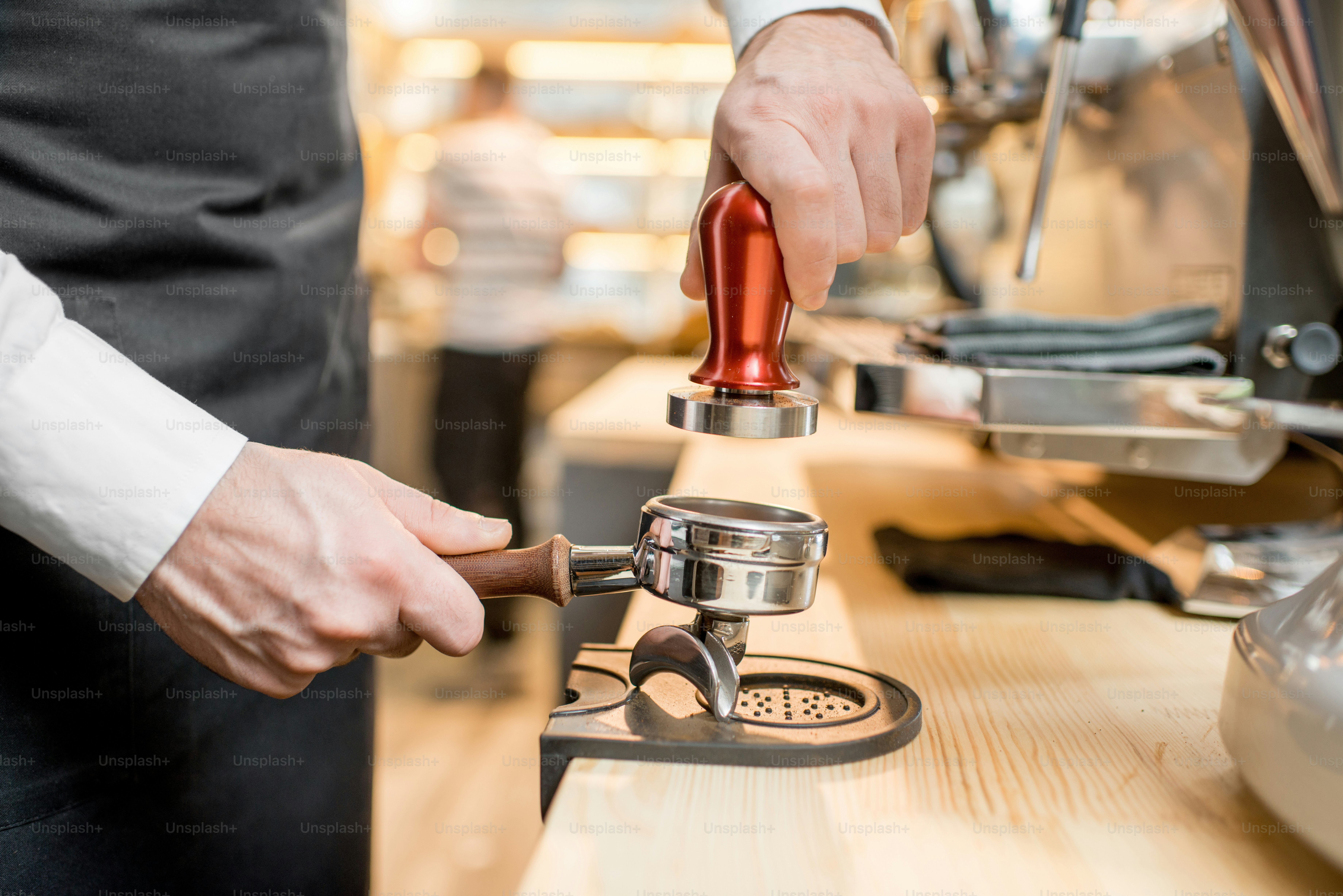 Pressing a coffee with temper into the handle of the professional ...