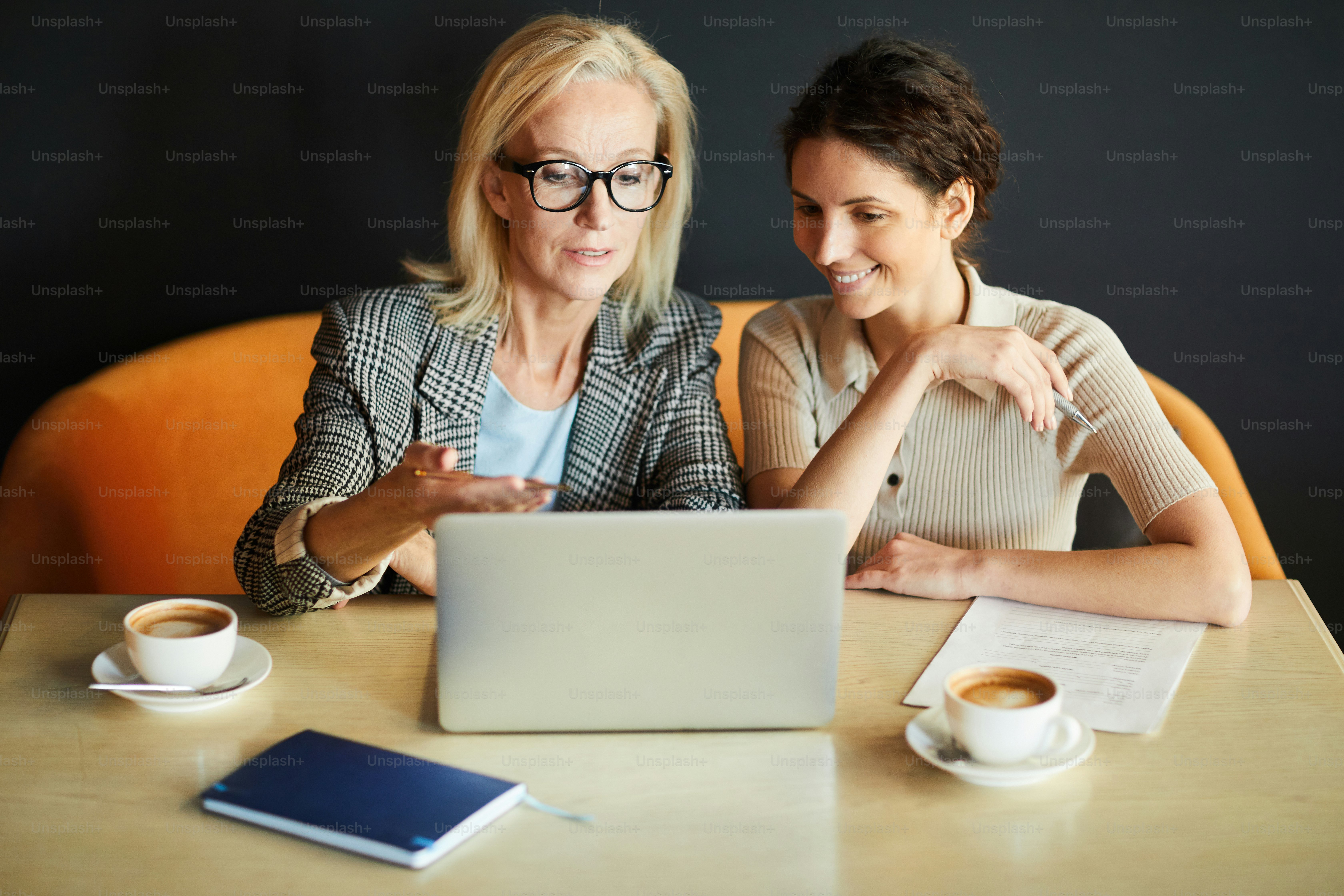 Blonde confident businesswoman making presentation of her ideas of interior design for restaurant to her assistant or partner