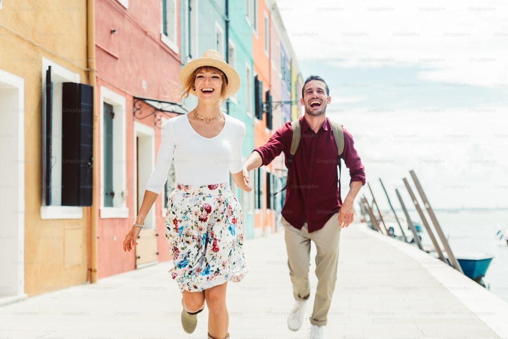 Couple of tourists on vacation in Venice, Italy - Two lovers having fun on city street - Tourism and love concept