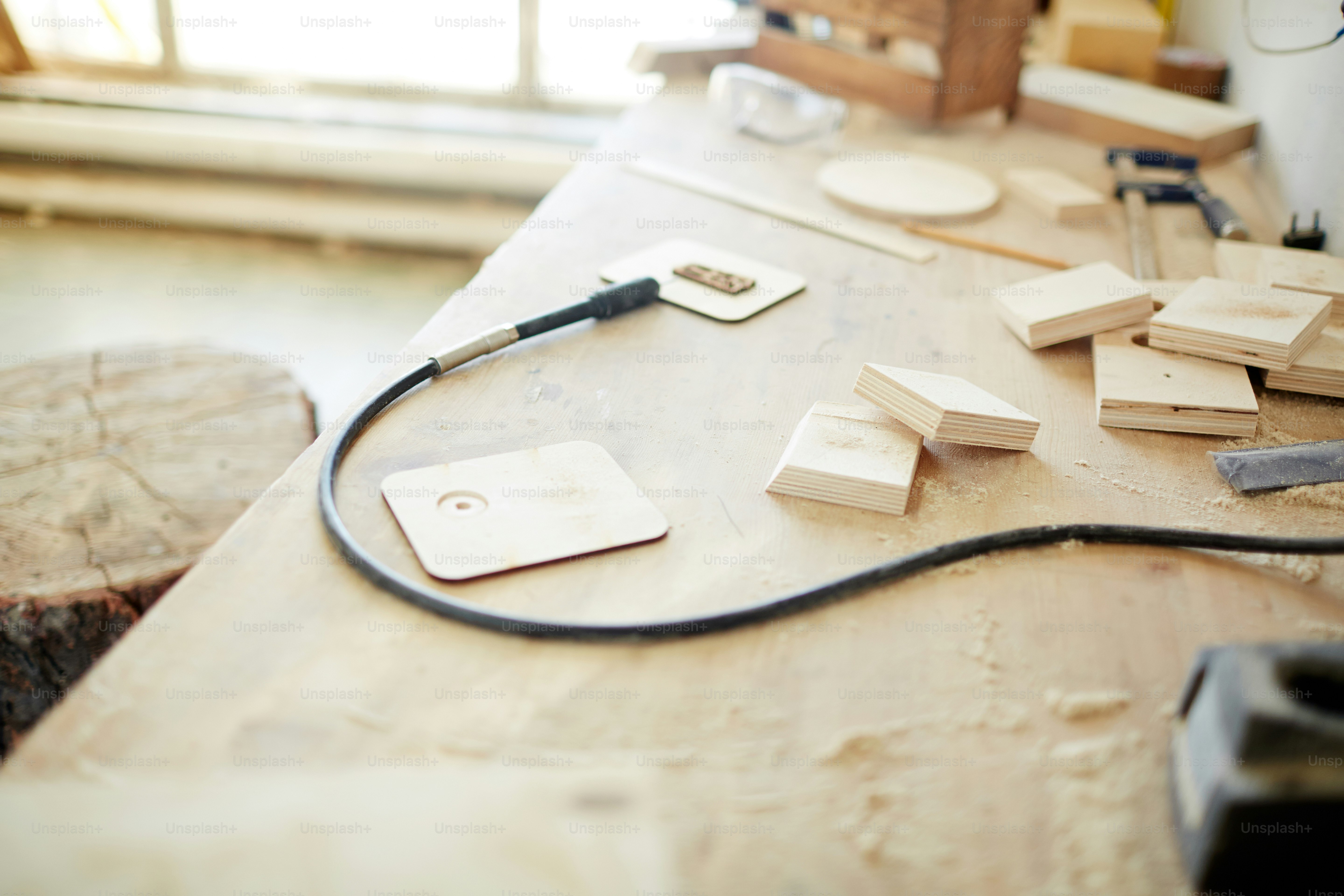 Pyrographic equipment and pieces of wooden planks on workbench of carpentry master