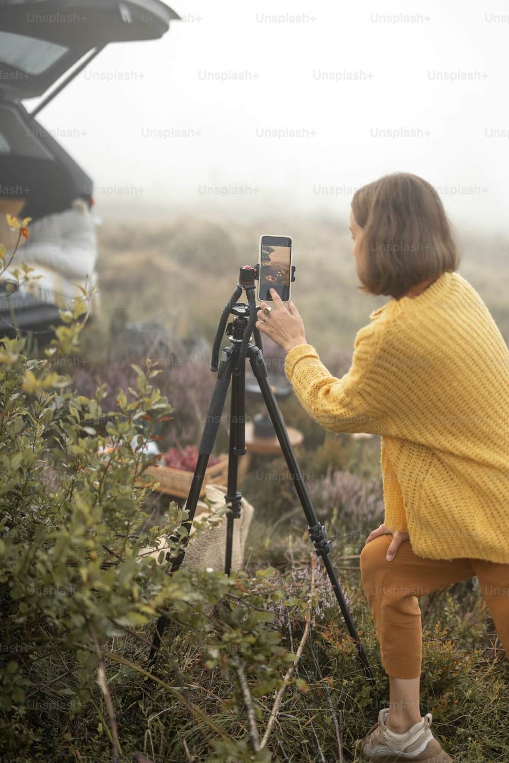 산을 여행하는 동안 피크닉에서 전화로 비디오를 촬영하는 여성 여행자