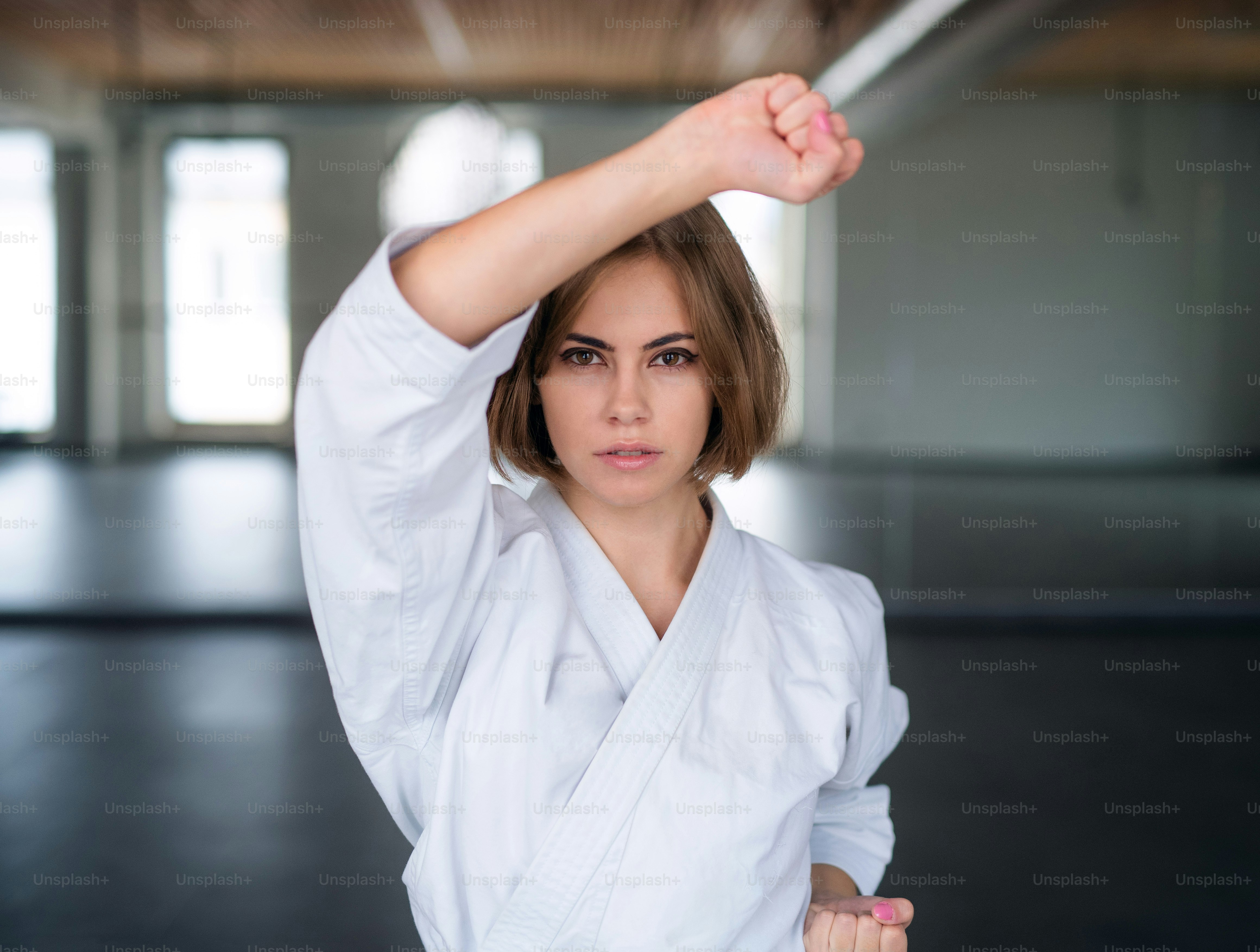 Una atractiva joven practicando karate en el gimnasio.