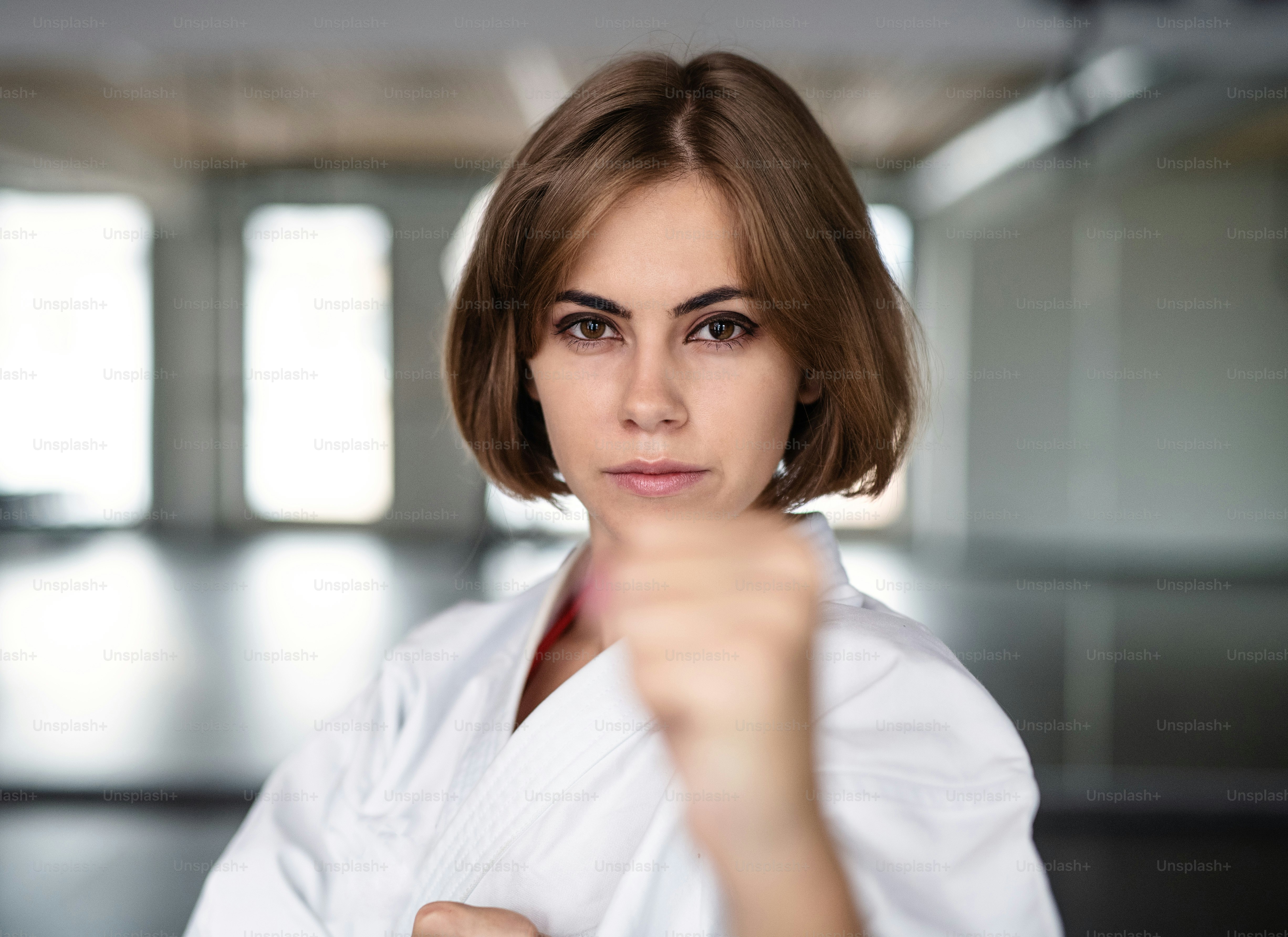 Una atractiva joven practicando karate en el gimnasio.