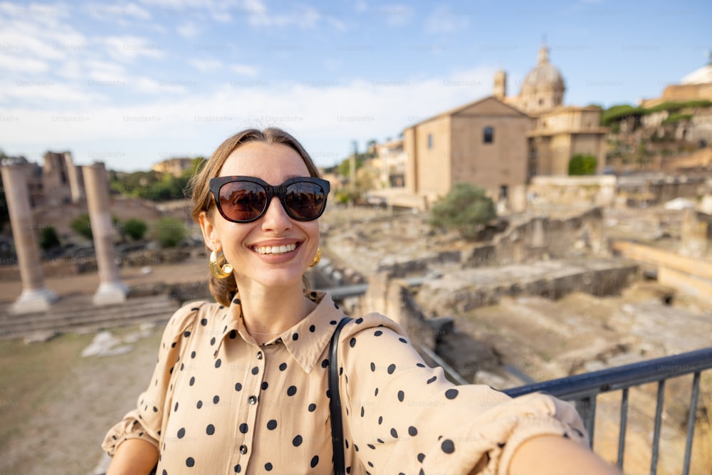 Retrato de una mujer frente al Foro Romano, ruinas en el centro de Roma. Concepto de viaje por lugares famosos de Italia. Mujer caucásica con vestido y chal en el pelo