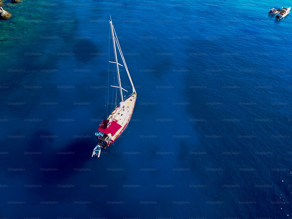 Bird's eyes view of sailboat on the turquoise exotic coral sea.