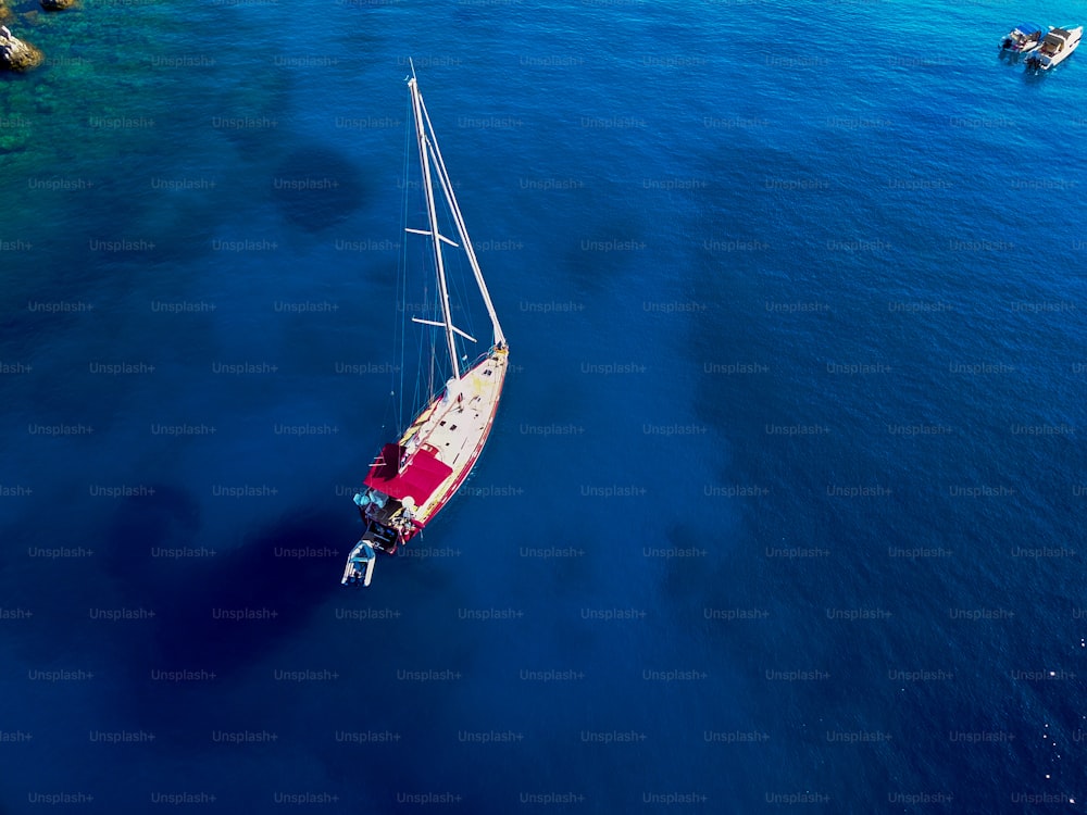 Bird's eyes view of sailboat on the turquoise exotic coral sea.