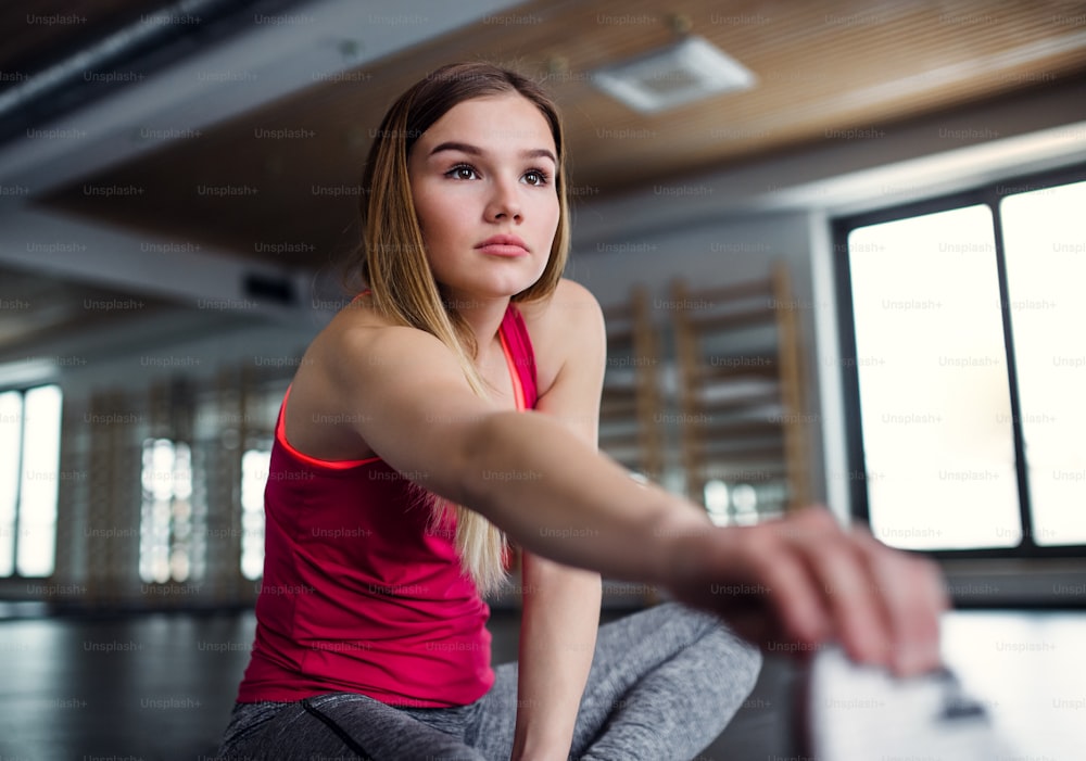 Ein Porträt eines schönen jungen Mädchens oder einer Frau, die in einem Fitnessstudio Sport treibt.