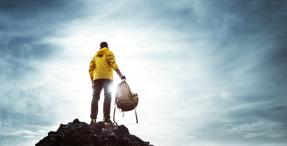 Escursionista con zaino che alza le braccia sulla cima della montagna - Uomo di successo che celebra la vittoria