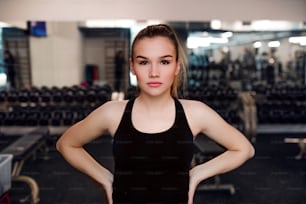 Um retrato de uma bela jovem menina ou mulher em pé em um ginásio.