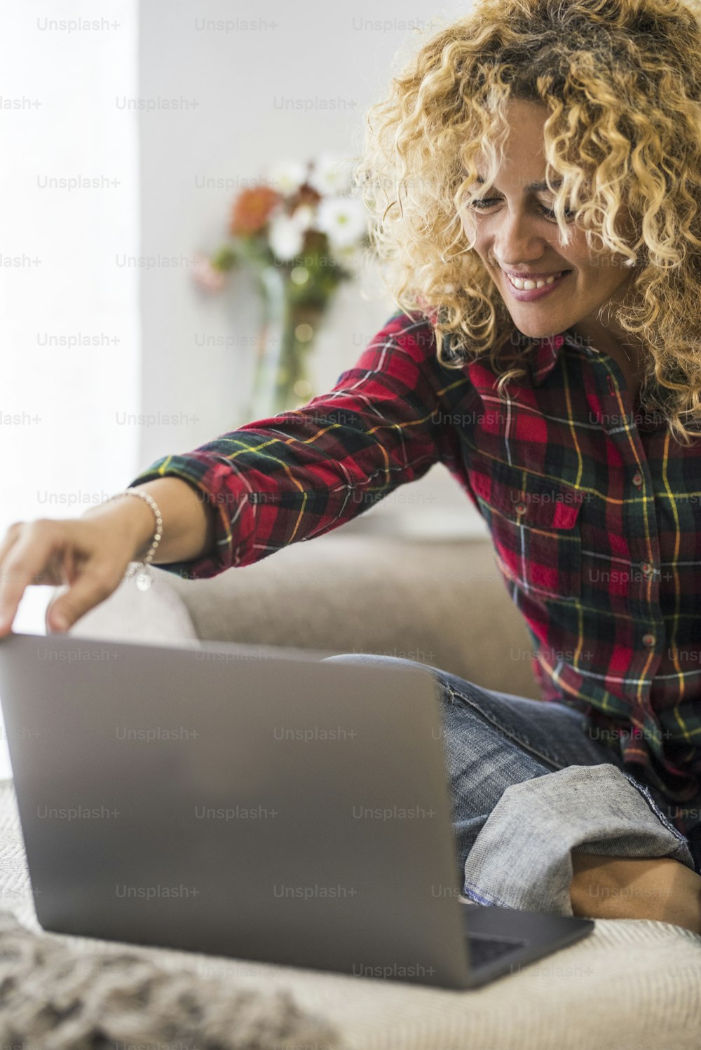 Middle age caucasian woman at home work and enjoy laptop computer sitting on the sofa - people and technology modern online lifestyle concept - smart workink or shopping web store free internet activity