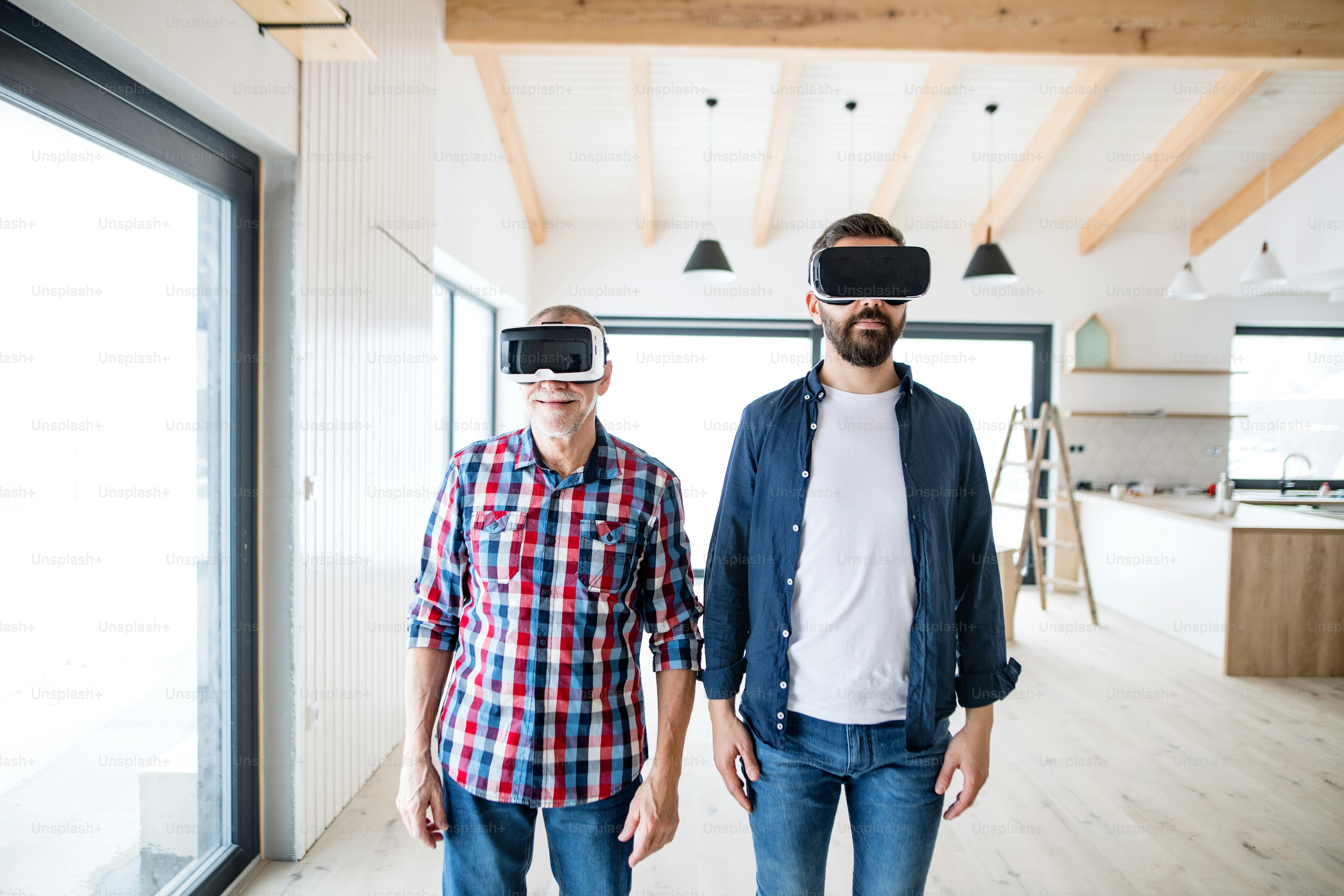 Un homme mûr avec des lunettes de réalité virtuelle et son père aîné qui meuble une nouvelle maison, un nouveau concept de maison.