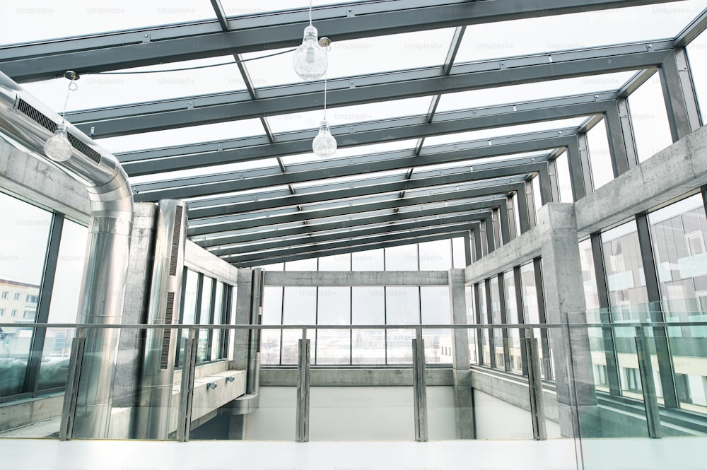Um interior de um moderno e espaçoso edifício de escritórios de vidro.