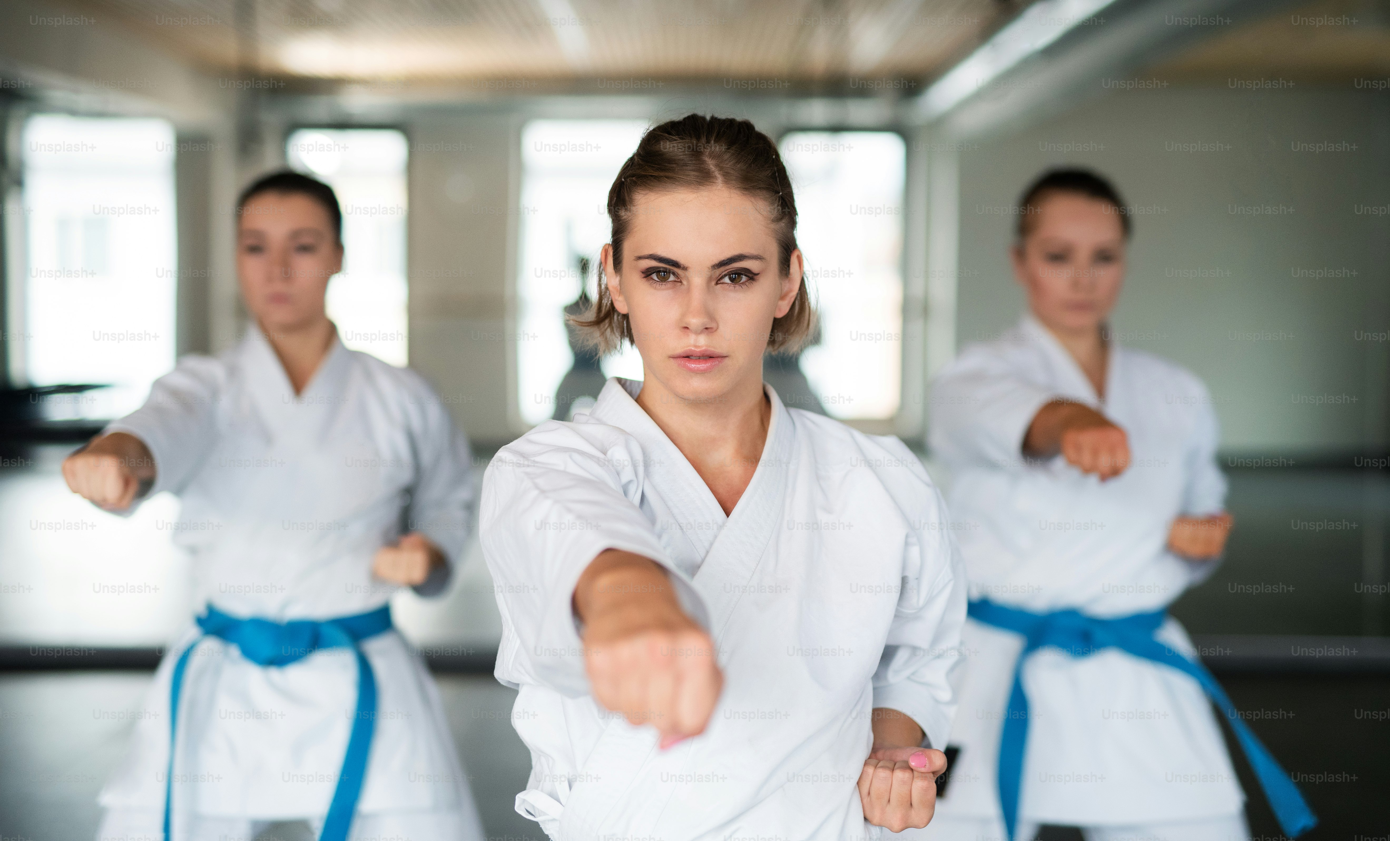 Un grupo de mujeres jóvenes practicando karate en el gimnasio.