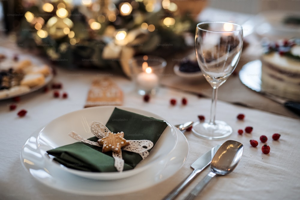 A close-up of plate on decorated table set for dinner meal at Christmas time.