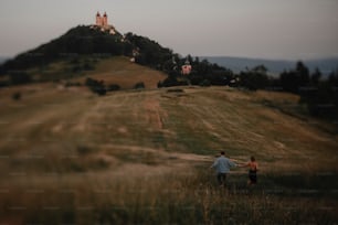 슬로바키아의 반스카 슈티아브니카(Banska Stiavnica) 시골의 황혼에 자연 속에서 산책하는 젊은 부부의 뒷모습.