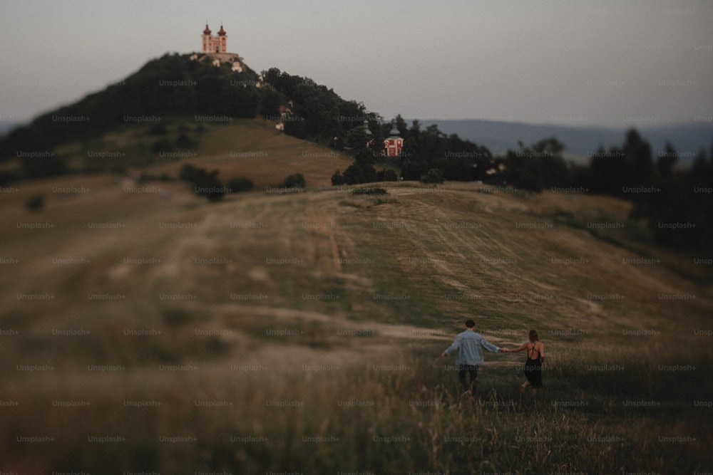 슬로바키아의 반스카 슈티아브니카(Banska Stiavnica) 시골의 황혼에 자연 속에서 산책하는 젊은 부부의 뒷모습.