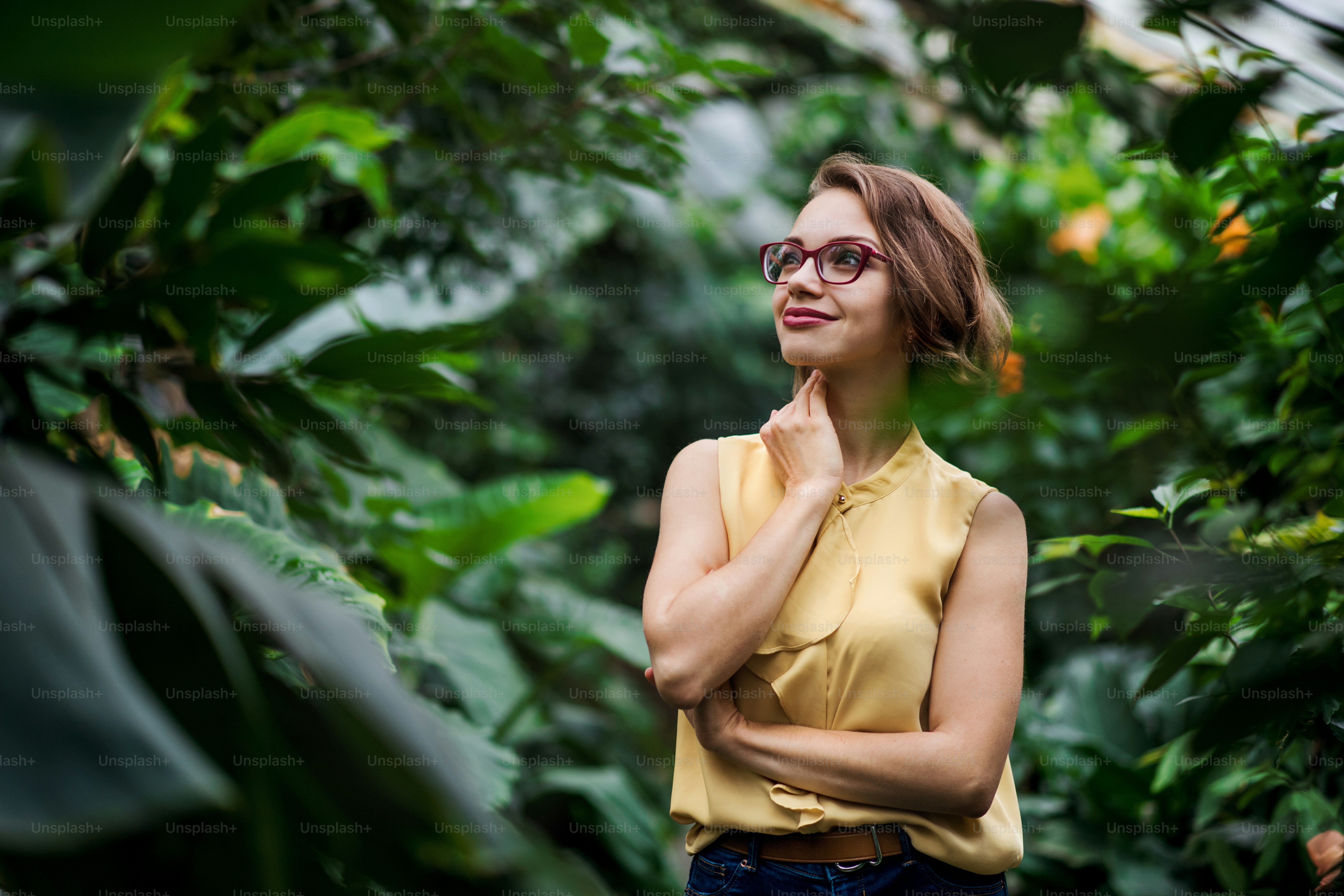 A young woman standing in botanical garden. Copy space