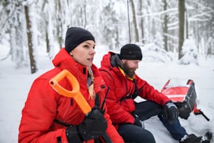 Servicio de rescate de montaña en operación al aire libre en invierno en el bosque, cavando nieve con palas. Concepto de avalancha.