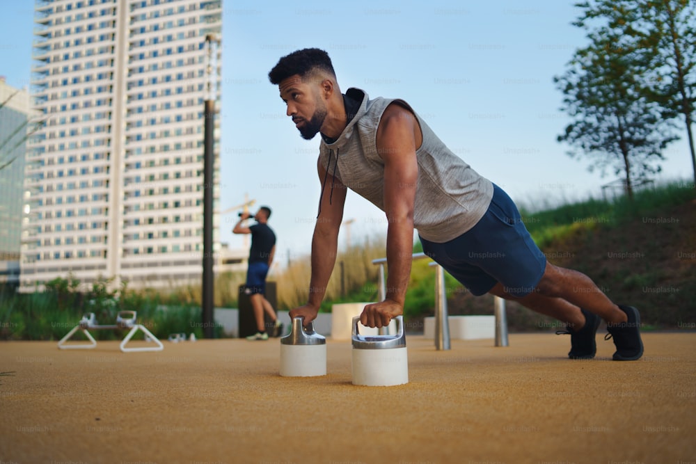 Um jovem fazendo flexões ao ar livre na cidade, exercícios de treino e conceito de estilo de vida saudável.