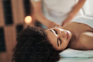 Retrato da mulher jovem tendo massagem no spa, relaxante.