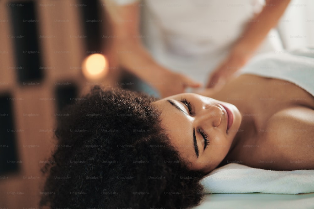 Portrait of young woman having massage at the spa, relaxing.