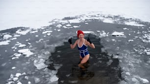 Una vista dall'alto della donna anziana attiva in costume da bagno all'aperto in inverno, concetto di terapia del freddo.