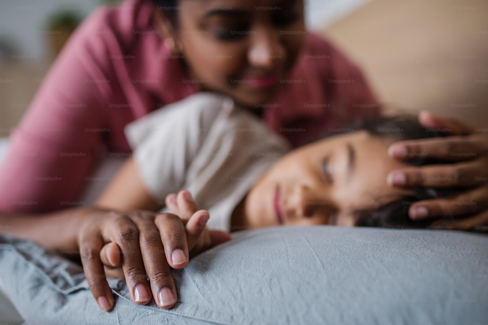 A mother taking care of her ill son at home.