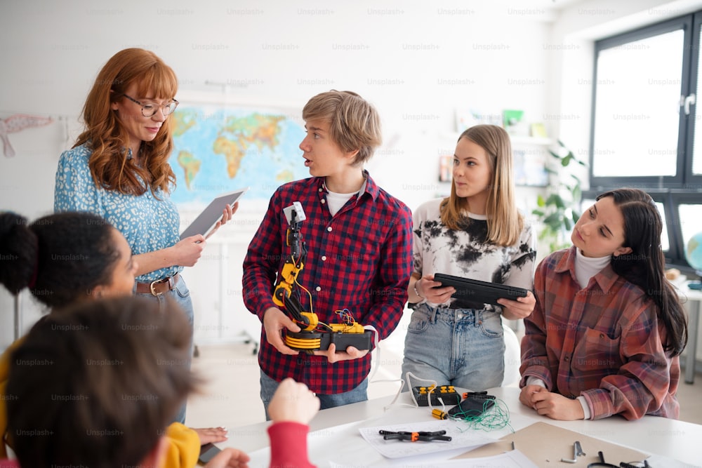 Eine Gruppe von Schülern, die elektrisches Spielzeug und Roboter im Robotik-Klassenzimmer bauen und programmieren