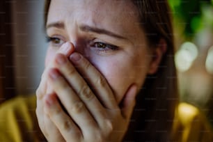 A woman suffering from depression and crying at home.