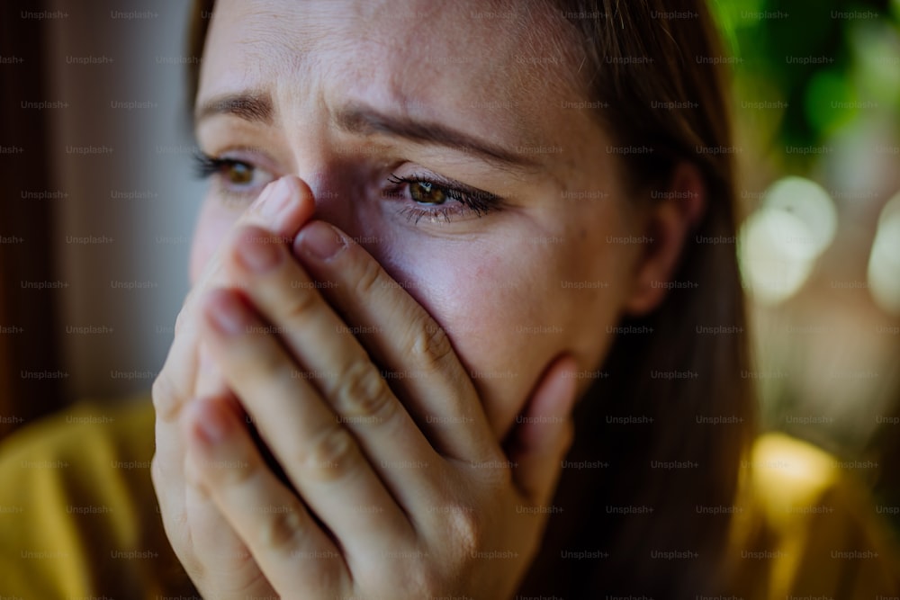 うつ病に苦しんで家で泣いている女性��。