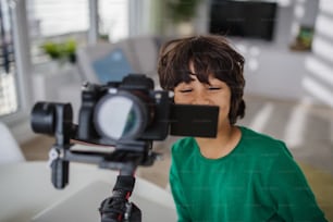 A happy multiracial boy cameraman amateur at home.