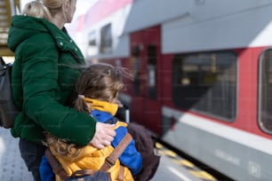Una mujer ucraniana con su hija despidiéndose y saludando a su familia en el tren que sale de Ucrania debido a la invasión rusa en Ucrania.