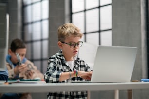 Niños en edad escolar usando la computadora en un aula en la escuela