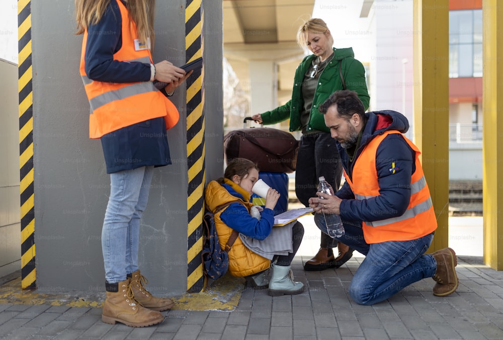 Volunteers helping an Ukrainian refugee family at train station.