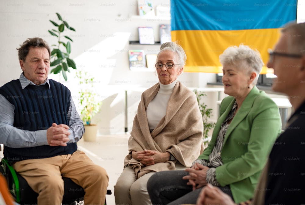 Um grupo de idosos orando pela Ucrânia juntos no centro comunitário da igreja.
