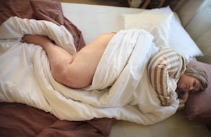 An overweight woman sleeping in bed at home.