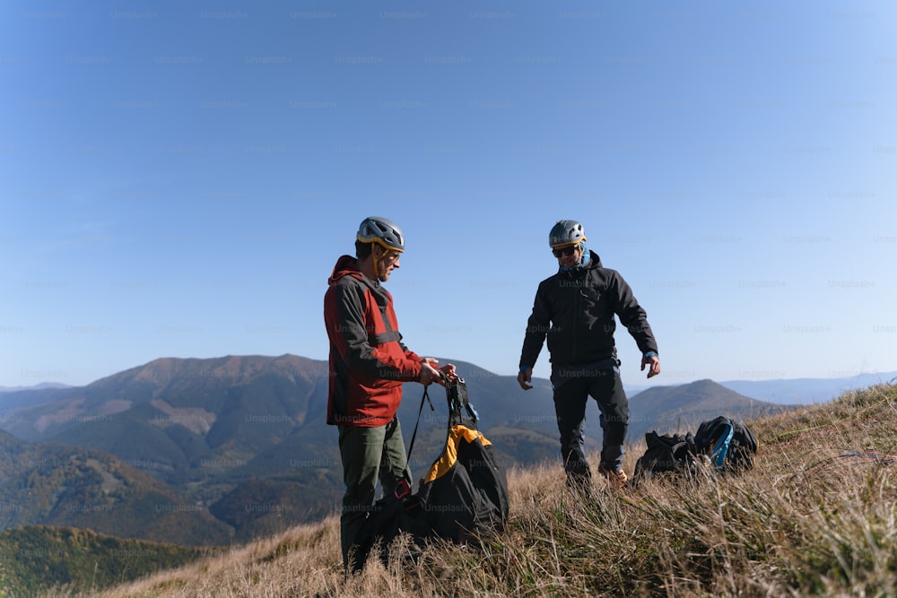 A man helping paragliding pilot to prepare for flight.