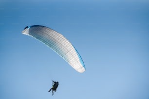 푸른 하늘의 패러 글라이더. 패러 글라이더를 타고 날아가는 스포츠맨.