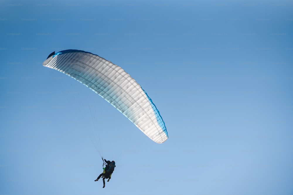 Um parapente no céu azul. O esportista voando em um parapente.