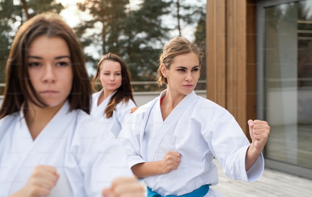 Eine Gruppe junger Frauen übt Karate im Freien auf der Terrasse.