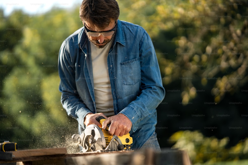 Un artisan travaillant avec une scie circulaire sur un chantier de construction