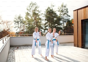 A group of young women practising karate outdoors on terrace.