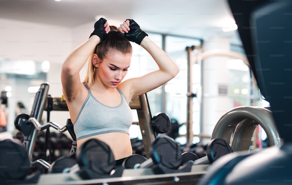 A portrait of a beautiful young girl or woman doing exercise in a gym.