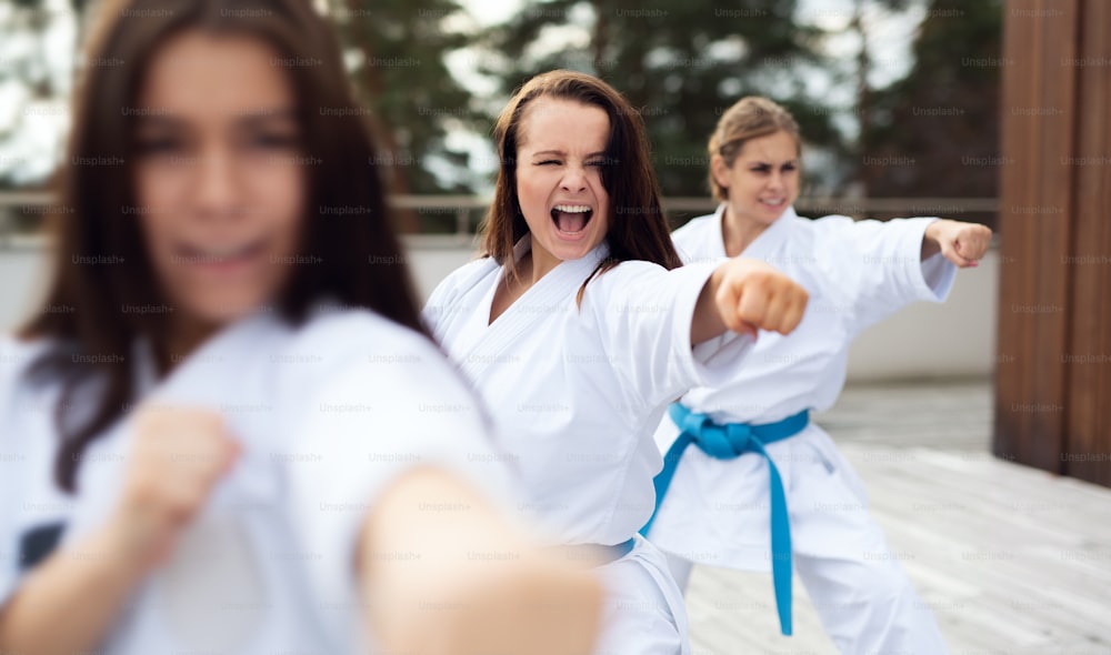 Un gruppo di giovani donne che praticano karate all'aperto su una terrazza.
