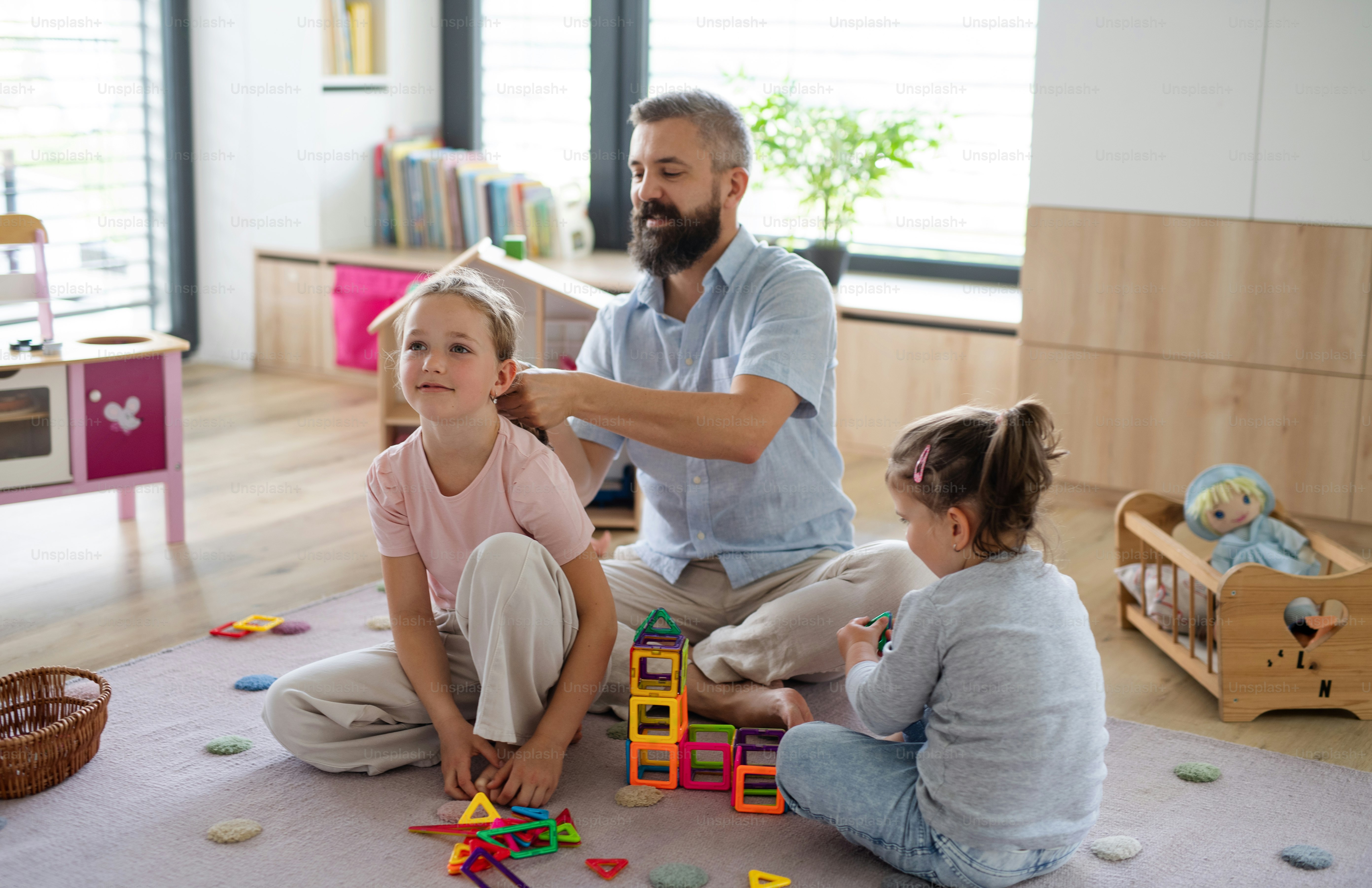 Un padre con tres hijas en casa, jugando y peinándose.