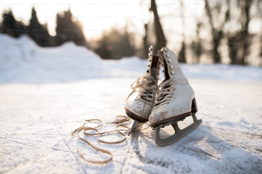 De vieilles patins à glace couchés sur la glace. Gros plan.